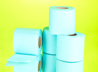 blue rolls of toilet paper on green background