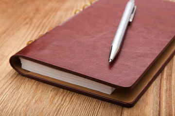 notepad with pen on wood table