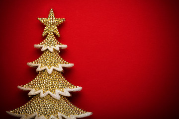 Fototapeta na wymiar golden christmas tree on red paper background