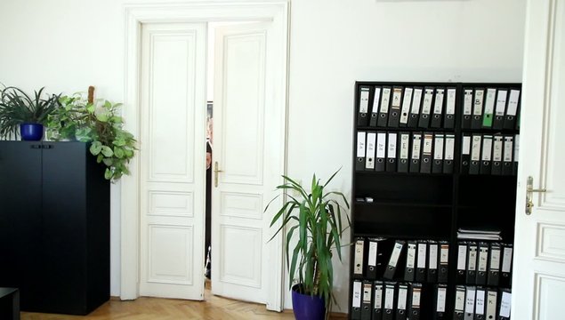 Ein Mann geht von einem B&uuml;rozimmer ins andere