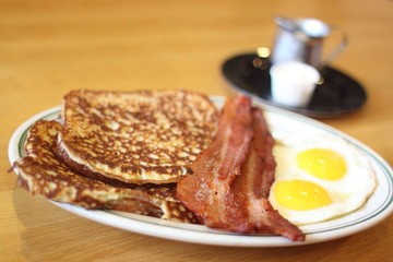 Delicious French toast with bacon and eggs for breakfast.