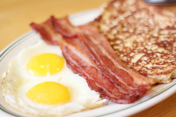 Delicious French toast with bacon and eggs for breakfast.