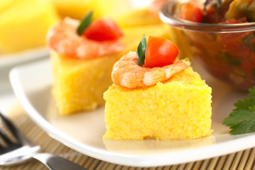 Polenta slices with shrimp and cherry tomato