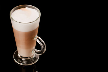 glass of latte over black background