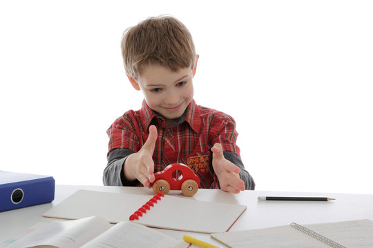 enfant gar&ccedil;on jouant pendant ses devoirs