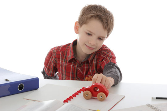 gar&ccedil;on enfant jouant pendant ses devoirs