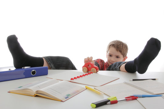 enfant gar&ccedil;on jouant pendant ses devoirs
