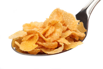 Cornflakes on a spoon over white background