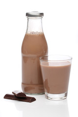 Bottle and glass of chocolate milk over white background
