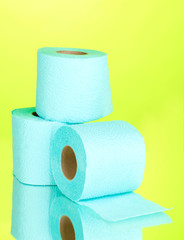 blue rolls of toilet paper on green background