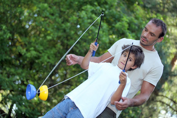 Father and son playing with diablo circus toy © auremar