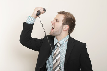 Naklejka premium A young businessman is angry with the phone