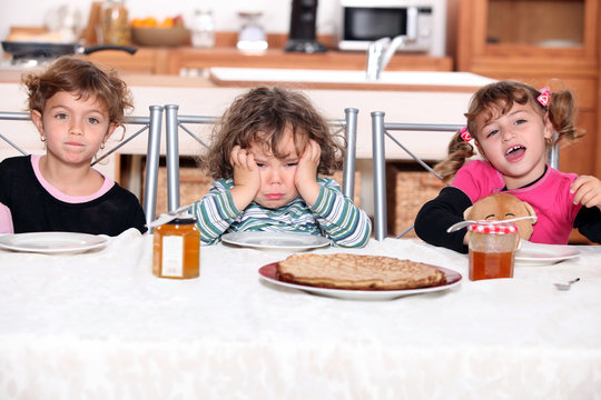 three children eating crepes