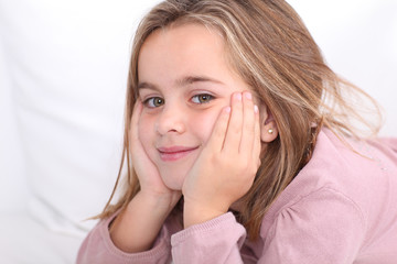 Portrait of cute little girl with hands on chin