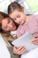 Mother and child using electronic tablet at home