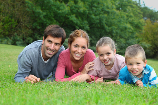 Portrait of happy family lying down in grass