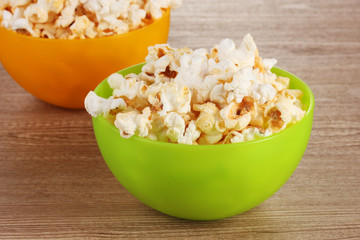 popcorn in bright plastic bowls on wooden table
