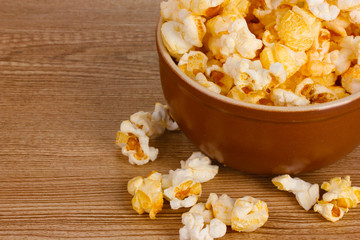 popcorn in brown bowl on wooden table