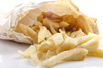 frisch gebratene Pommes frites in einer hellen Tüte mit Salz