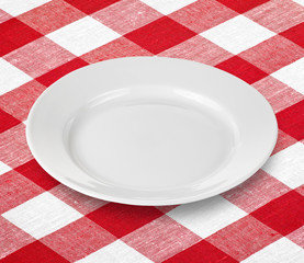 white empty plate on red gingham tablecloth
