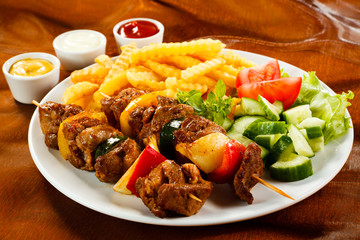 Grilled meat, French fries and vegetables