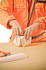 Obraz na płótnie Canvas ręce robotnika zrobić papierowy statek