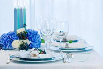 Gedeckter Tisch mit blauen Kerzen