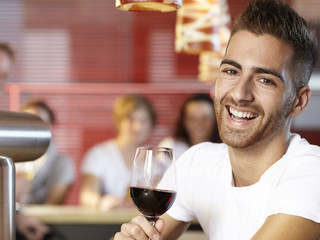 A single man with a glass of wine sitting in a pub