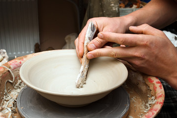 hands of a potter, creating an earthen jar on the circle