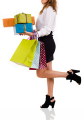Elegant woman carrying shopping bags and gifts on white backgrou