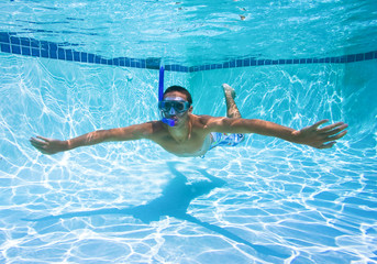 Young Man Swimming in Pool Underwater