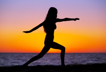 Silhouette of a beautiful Yoga woman at Sunset