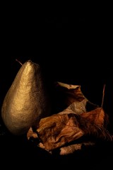 abstract composition with golden pear and leaves