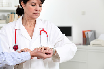 Doctor taking her patient's pulse