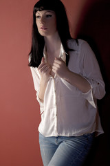 Young woman in casual clothes leaning against wall