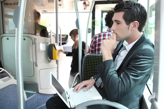 Commuter on a bus with a laptop