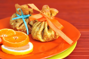 Pancakes with lemon and slices of orange