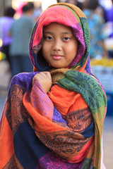 girl and colorful silk clothes cover her head