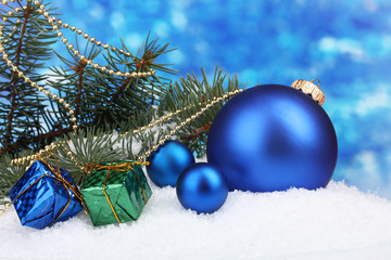 Fototapeta na wymiar Christmas ball and toy with green tree in the snow on blue
