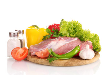 Raw meat and vegetables on a wooden board isolated on whitе