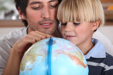 Father and son looking at globe