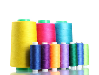 Many-coloured bobbins of thread isolated on white