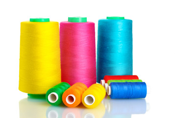 Many-coloured bobbins of thread isolated on white