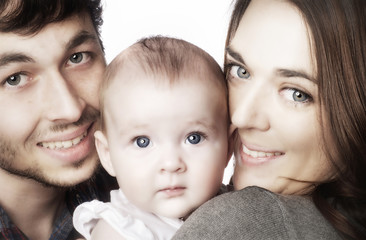 Young couple hugging their baby girl