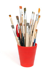 paint brushes in red glass