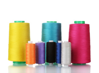 Many-coloured bobbins of thread isolated on white