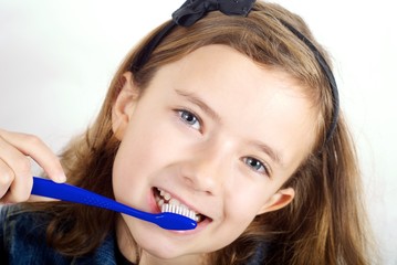 Girl brushing teeth on white background