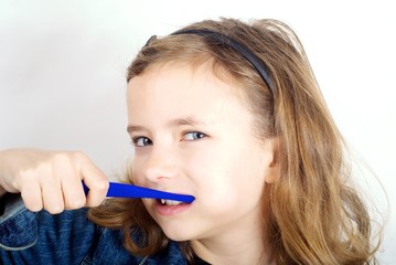 Girl brushing teeth on white background