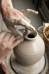 hands of a potter, creating an earthen jar on the circle