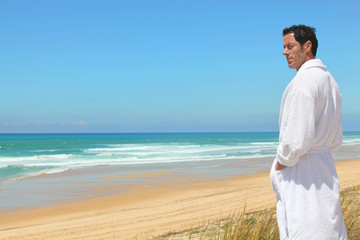 Fototapeta na wymiar Man on the beach in towelling robe